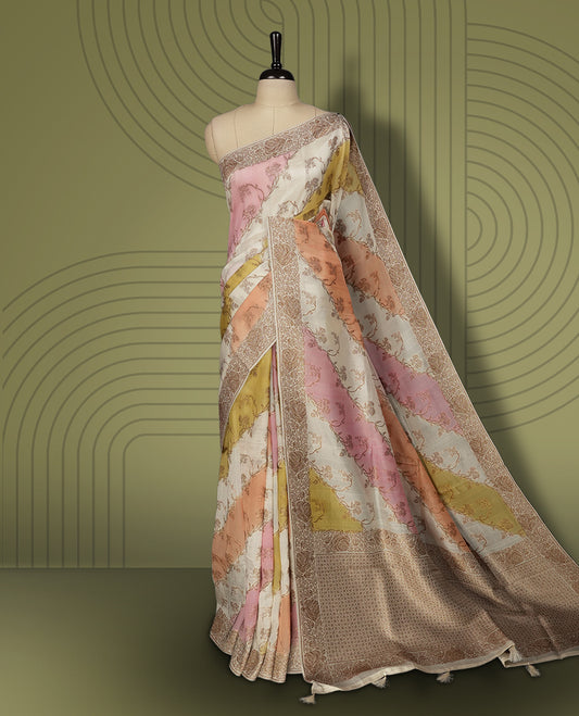 Pastel cream colour semi Banarasi Tussar Georgette saree with soft peach, lilac, and sage yellow floral motifs, antique gold zari border, and intricately woven pallu. Comes with matching blouse piece.