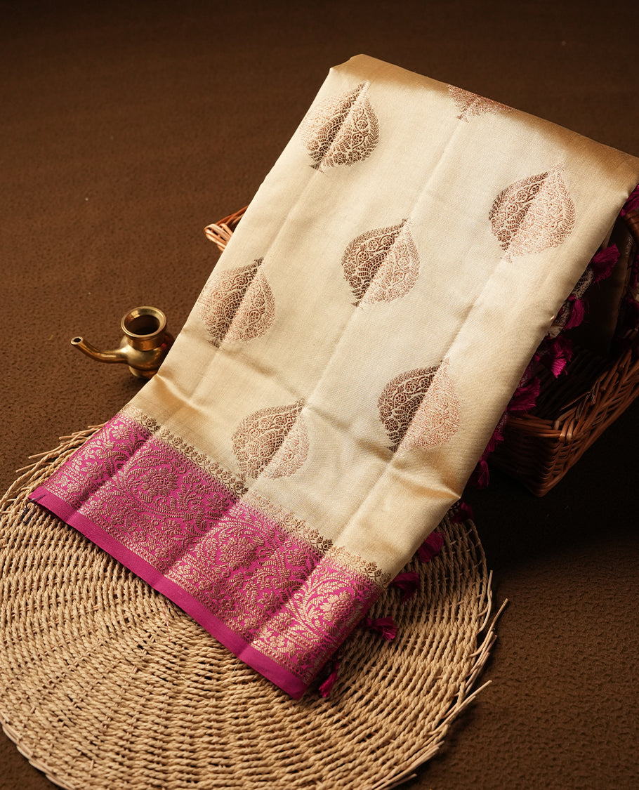 Cream beige Banaras soft silk saree with gold zari oval motifs on body, with contrast Pink colour floral pattern on pallu, border, and Matching blouse.