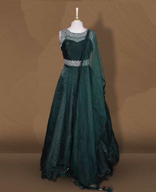 Emerald green colour Gown with stitched sleeveless blouse featuring embellished neckline and waist detailing, paired with a matching stitched flared lehenga and sheer dupatta.