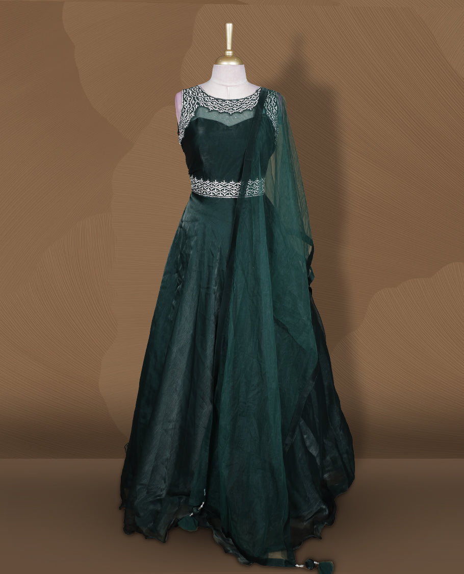 Emerald green colour Gown with stitched sleeveless blouse featuring embellished neckline and waist detailing, paired with a matching stitched flared lehenga and sheer dupatta.