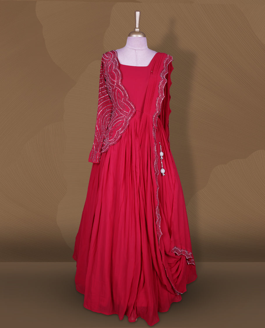 Rani pink colour stitched gown set with square neckline, attached pleated flare, and one‑side draped dupatta highlighted with heavy silver sequin and mirror work border and sleeve.