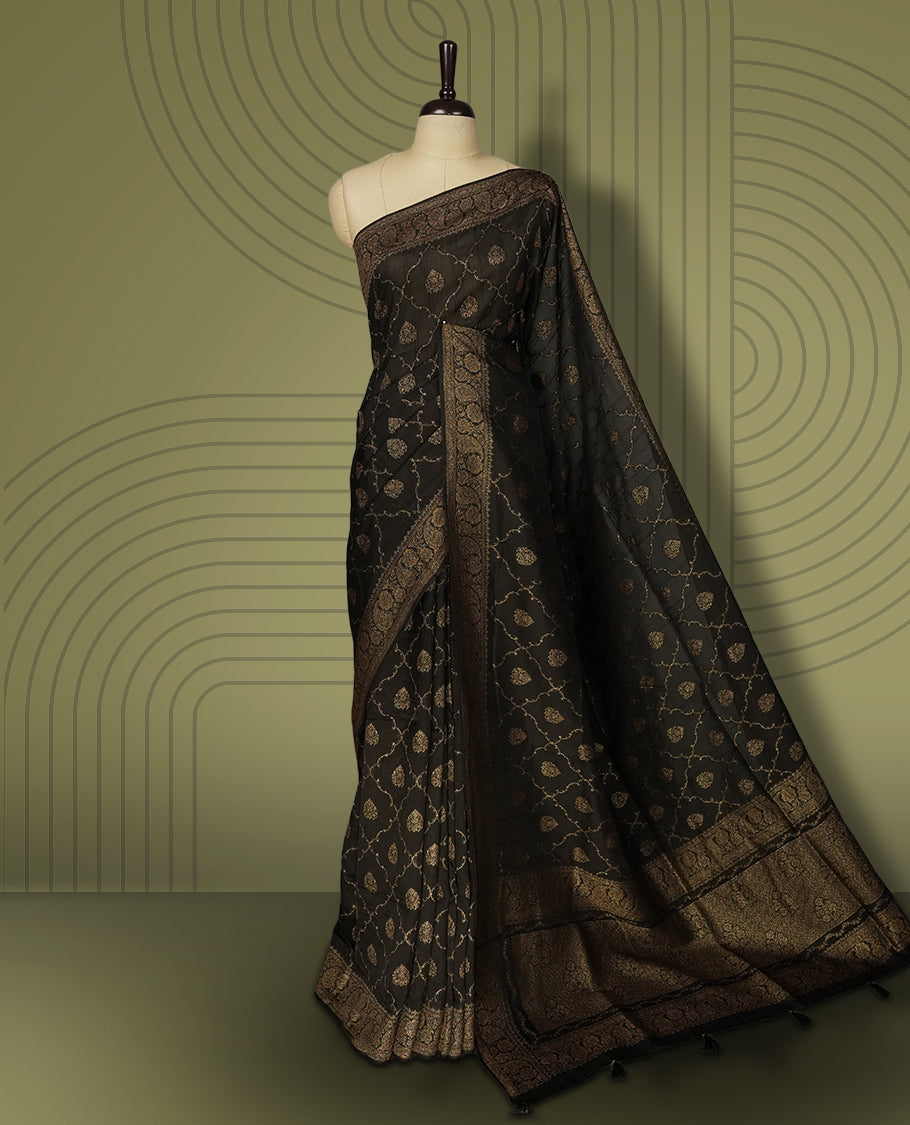 Black colour semi Banarasi Tussar Georgette saree with gold zari motifs on the body, a grand woven golden pallu, and ornate zari border, Includes a matching blouse piece for a complete look.