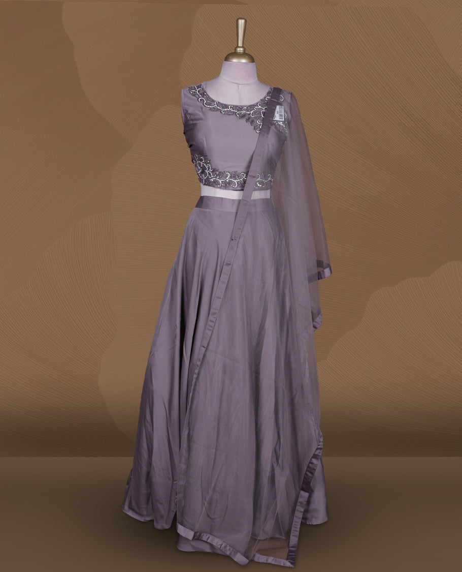 Dusty lavender colour lehenga set with stitched sleeveless blouse featuring intricate bead and sequin embroidery along the neckline and waist, paired with a matching stitched flared lehenga and plain sheer dupatta.