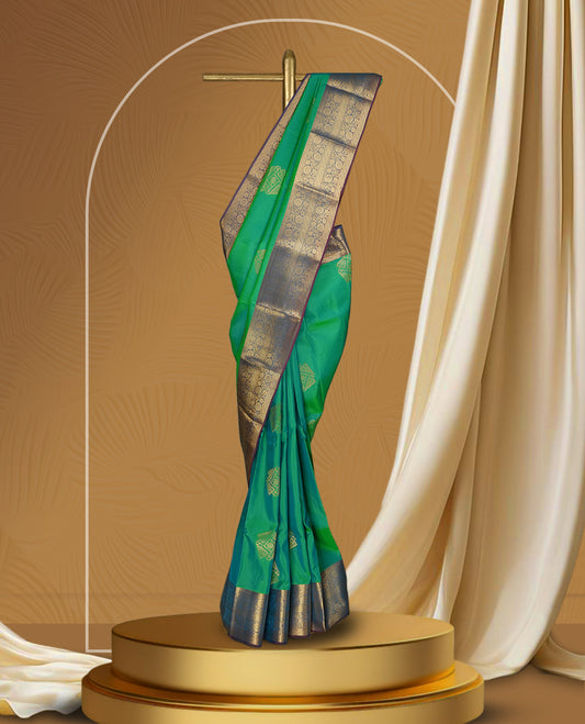 Parrot green colour soft silk saree adorned with golden zari motifs, enhanced by a rich purple zari border and pallu with intricate designs & paired with a matching blouse.