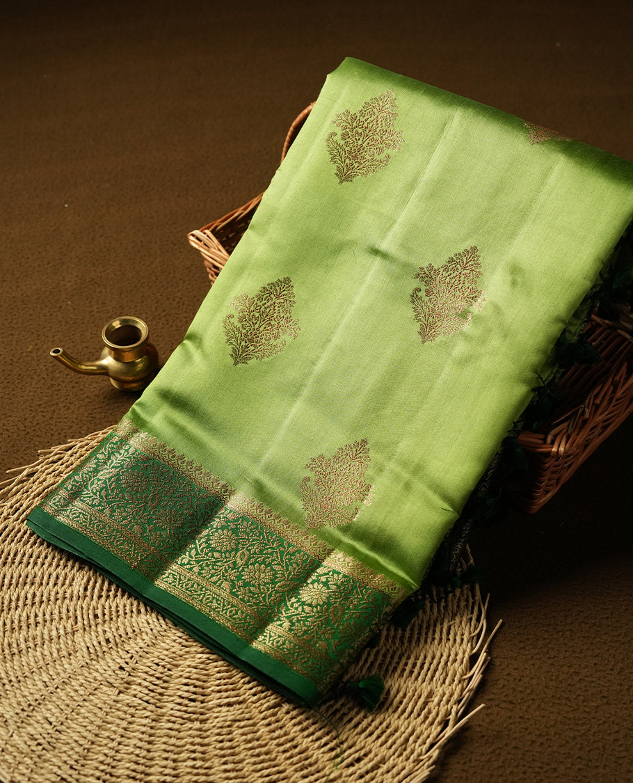 Green Banaras soft silk saree with gold zari motifs on body, with contrast Dark green colour floral pattern on pallu, border, and Matching blouse.