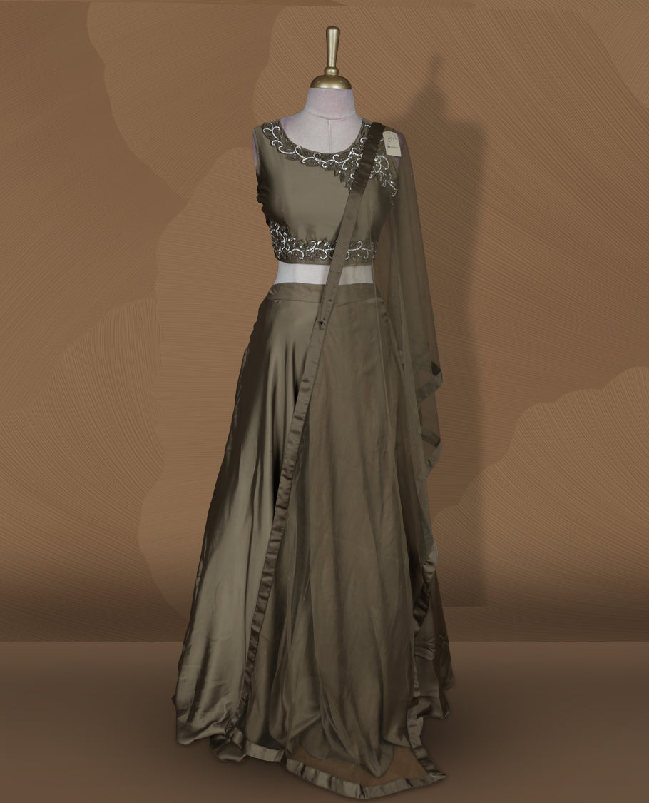 Olive brown colour lehenga set with stitched sleeveless embroidered blouse, matching stitched flared lehenga, and plain sheer dupatta with satin border.