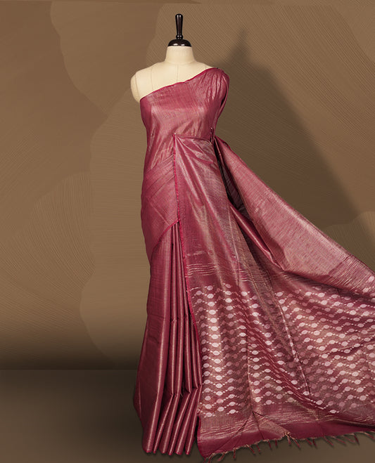 Burgundy brown colour semi jute tissue saree featuring delicate wave motifs on the body, complemented by a lustrous zari striped pallu and matching blouse piece for a refined festive look.