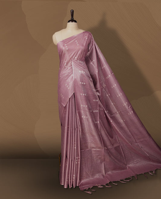 Soft Mauve colour semi jute tissue saree adorned with delicate dotted motifs all over, Features a finely woven pallu and sleek borders for a refined look & Comes with a matching blouse piece.