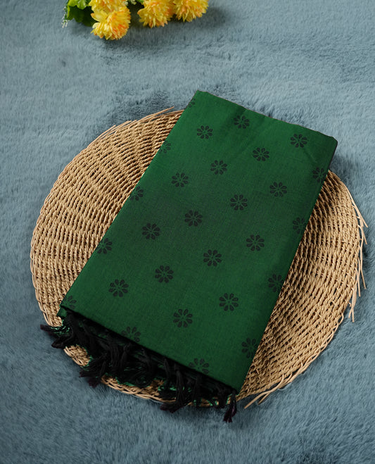 Green colour poly cotton saree with black floral butti motifs on the body, paired with a matching pallu featuring black ornate floral jaal and stripes on the border, and a coordinated all‑over black paisley printed blouse piece. (Copy)