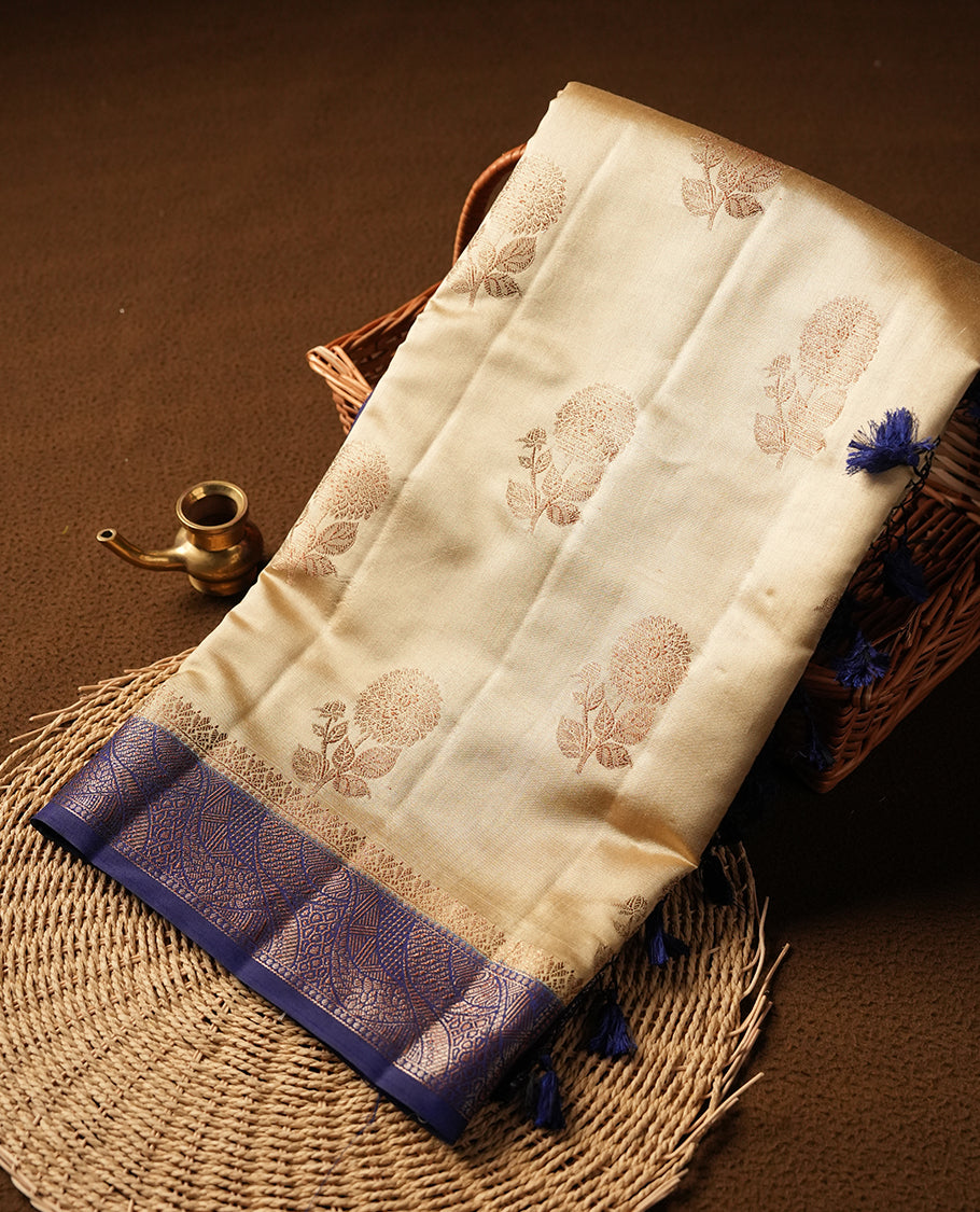 Cream beige Banaras soft silk saree with gold Floral motifs on body, with contrast Blue colour floral pattern on pallu, border, and Matching blouse.