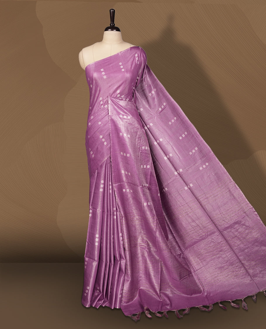 Lavender colour semi jute saree adorned with delicate woven motifs and a subtle sheen, The tassel detailed pallu enhances its charm & Paired with a matching blouse piece for an elegant finish.