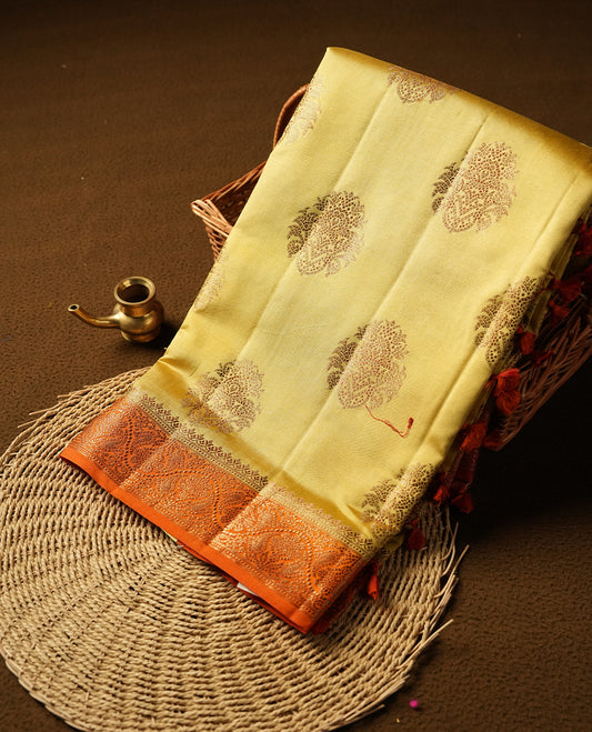 Gold Banaras soft silk saree with Antique zari motifs on body, with contrast Orange colour floral pattern on pallu, border, and Matching blouse.