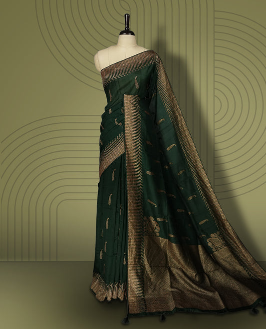 Dark green colour semi Banarasi Tussar Georgette saree with delicate gold zari buttas on the body, a rich golden zari pallu, and detailed woven border & Comes with a matching blouse piece.
