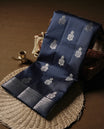 Pastel navy blue colour pure banarasi tussar soft silk saree adorned with delicate silver motifs all over the body, complemented by an intricate Banarasi style silver zari border & Comes with a matching blouse piece.