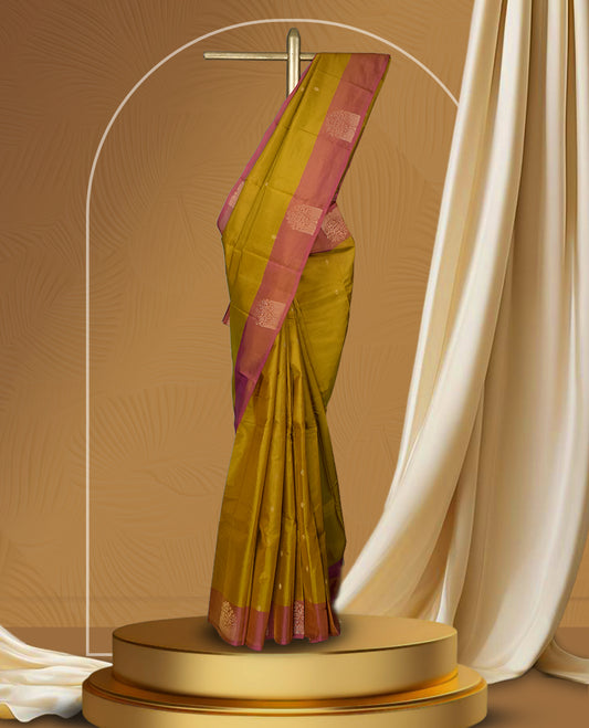 Mustard yellow colour soft silk saree highlighted with a rich contrast pink border adorned with elegant zari motifs & Paired with a matching blouse.