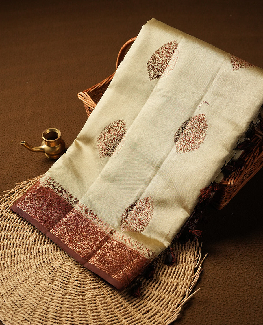 Cream beige Banaras soft silk saree with gold zari oval motifs on body, with contrast Chocolate brown colour floral pattern on pallu, border, and Matching blouse.