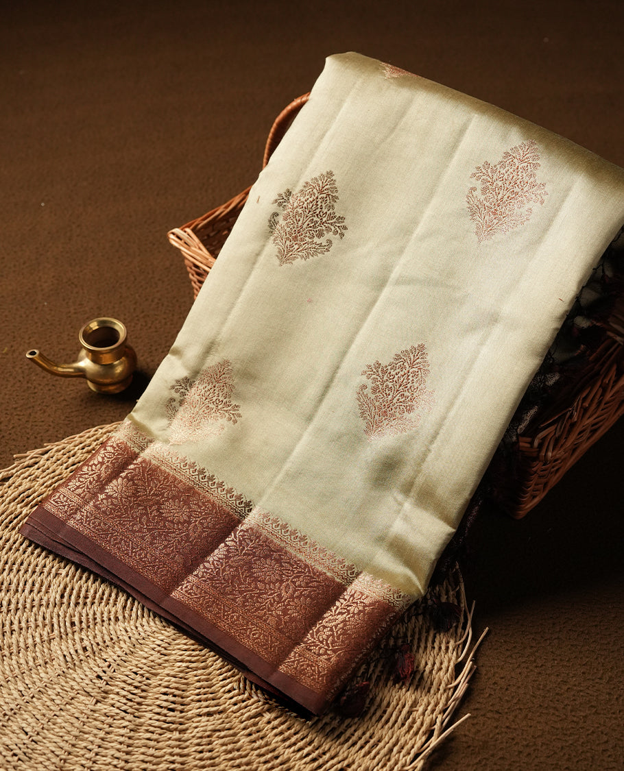 Cream beige Banaras soft silk saree with gold zari motifs on body, with contrast Chocolate brown colour floral pattern on pallu, border, and Matching blouse.