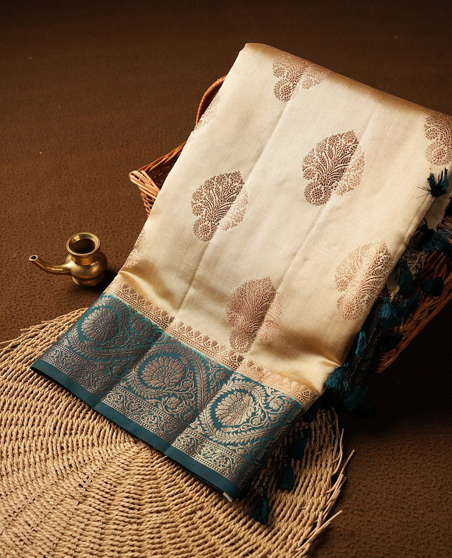 Gold Cream Banaras soft silk saree with gold zari oval motifs on body, with contrast Teal colour floral pattern on pallu, border, and Matching blouse.