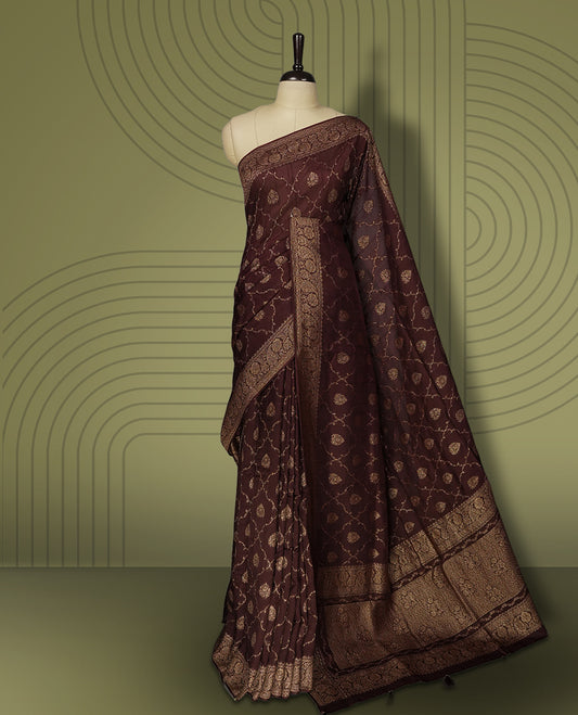 Coffee brown colour semi Banarasi Tussar Georgette saree with gold zari motifs on the body, a grand woven golden pallu, and ornate zari border. Includes a matching blouse piece for a complete look.