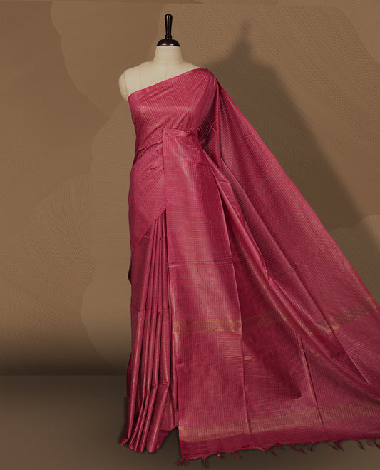 Medium maroon colour semi jute saree with golden checked body for a traditional appeal, Soft texture, tassel pallu, and Includes matching blouse piece for a complete look.