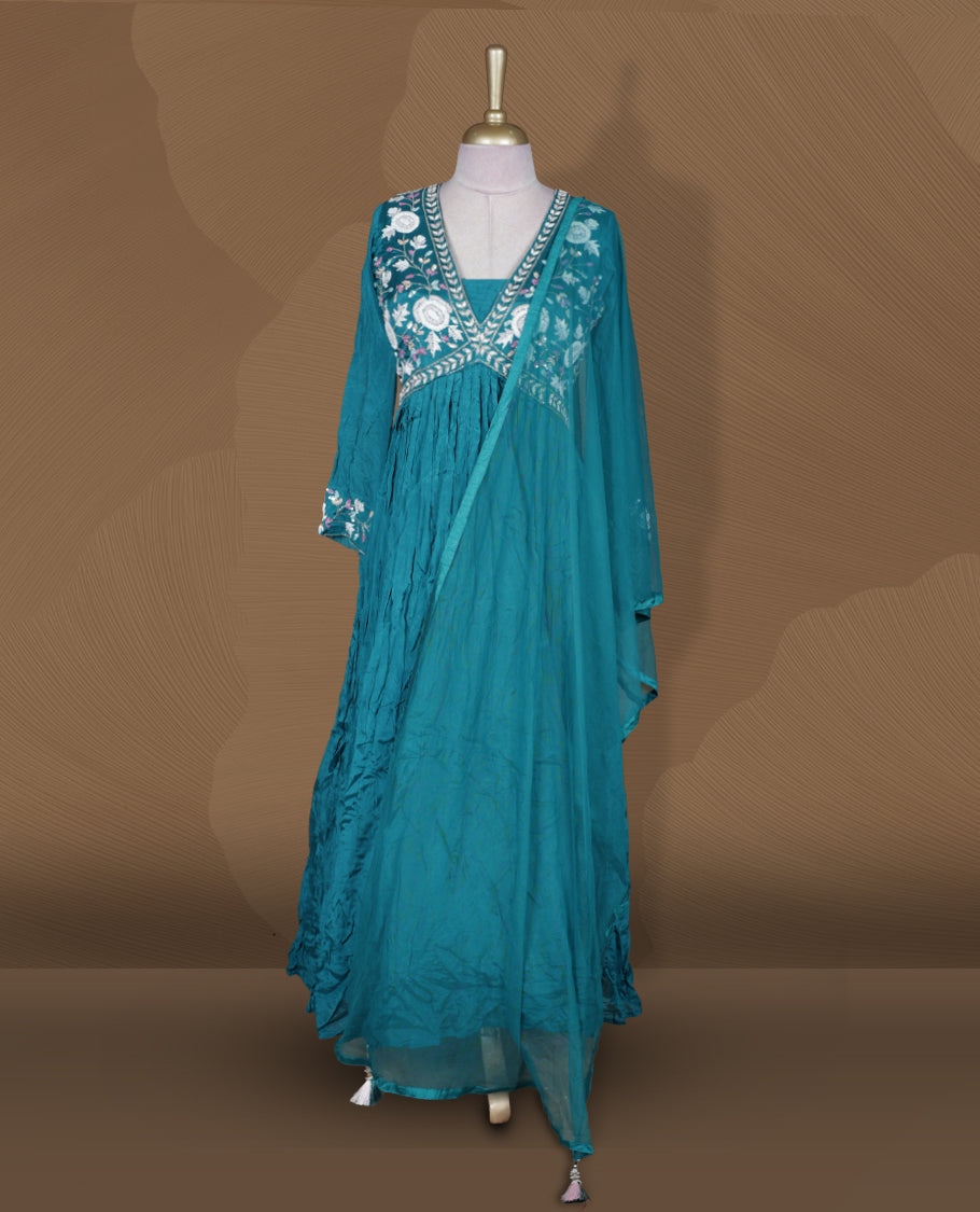 Teal green colour stitched gown set with V‑neck floral embroidered yoke, gathered flare, full sleeves with cuff embroidery, and matching plain sheer dupatta.