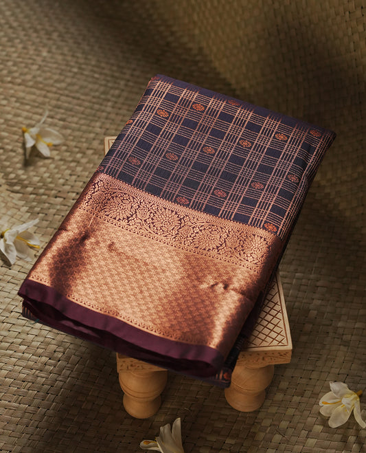 Dark blue colour Semi Silk Saree with copper zari checkered on the body, paired with a contrast chocolate brown colour pallu with copper zari traditioal border, and a matching blouse piece.