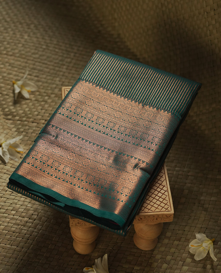 Dark green colour Semi Silk Saree with gold zari stripes on the body, paired with a contrast rani pink colour pallu with coppper zari traditioal border, and a matching blouse piece.