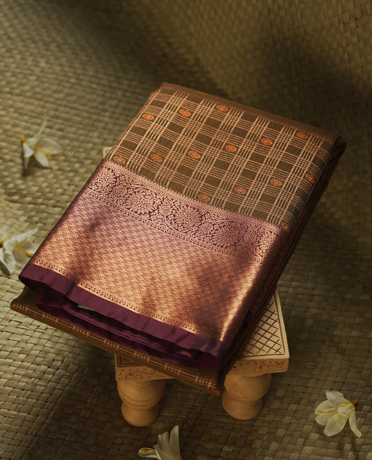 Olive brown colour Semi Silk Saree with copper zari checkered on the body, paired with a contrast burnt maroon colour pallu with copper zari traditioal border, and a matching blouse piece.