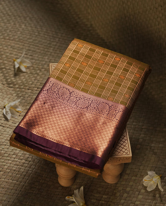 Khaki green colour Semi Silk Saree with gold zari stripes on the body, paired with a contrast Dark brown colour pallu with gold zari traditioal border, and a matching blouse piece.