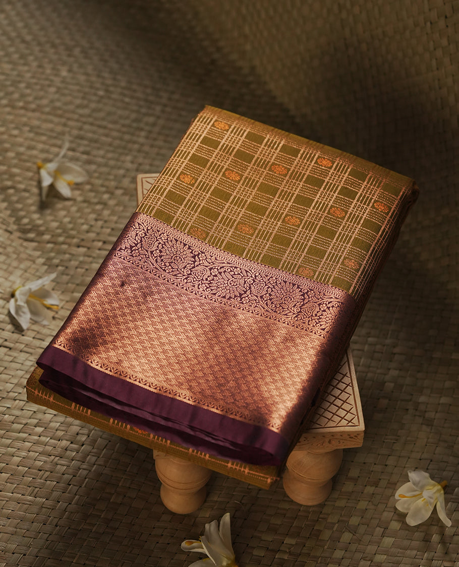 Khaki green colour Semi Silk Saree with gold zari stripes on the body, paired with a contrast Dark brown colour pallu with gold zari traditioal border, and a matching blouse piece.