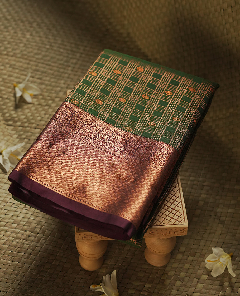 Dark green colour Semi Silk Saree with gold zari stripes on the body, paired with a contrast Burnt maroon colour pallu with gold zari traditioal border, and a matching blouse piece.