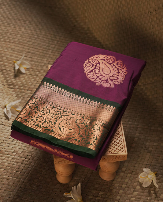 Dark Purple colour Semi Silk Saree with gold zari motifs on the body, paired with a contrast Dark green colour pallu with gold zari traditioal border, and a matching blouse piece.