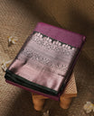 Purple colour Semi Silk Saree with rose gold zari checkered on the body, paired with a contrast Dark green colour pallu with Rose gold zari traditioal border, and a matching blouse piece.