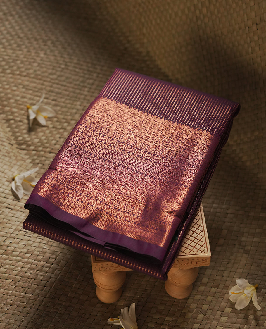 Dark Purple colour Semi Silk Saree with copper zari stripes on the body, paired with a contrast Khaki green colour pallu with copper zari traditioal border, and a matching blouse piece.