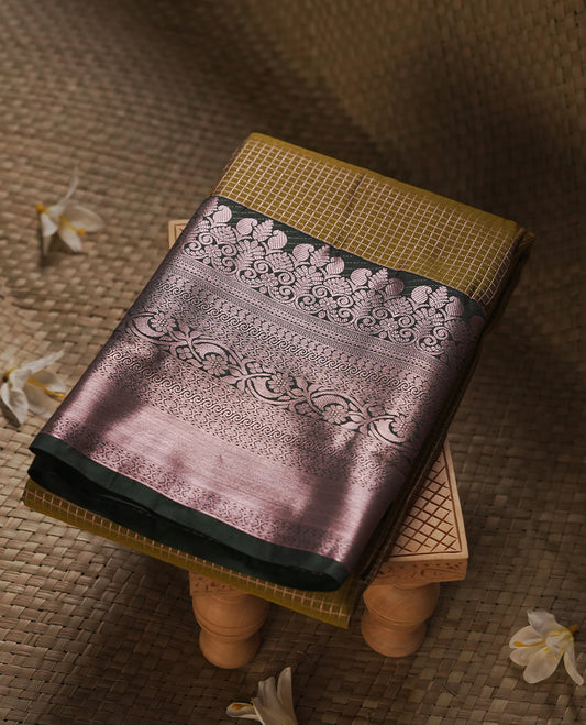 Olive brown colour Semi Silk Saree with copper zari checkered on the body, paired with a contrast Dark green colour pallu with Rose gold zari traditioal border, and a matching blouse piece.
