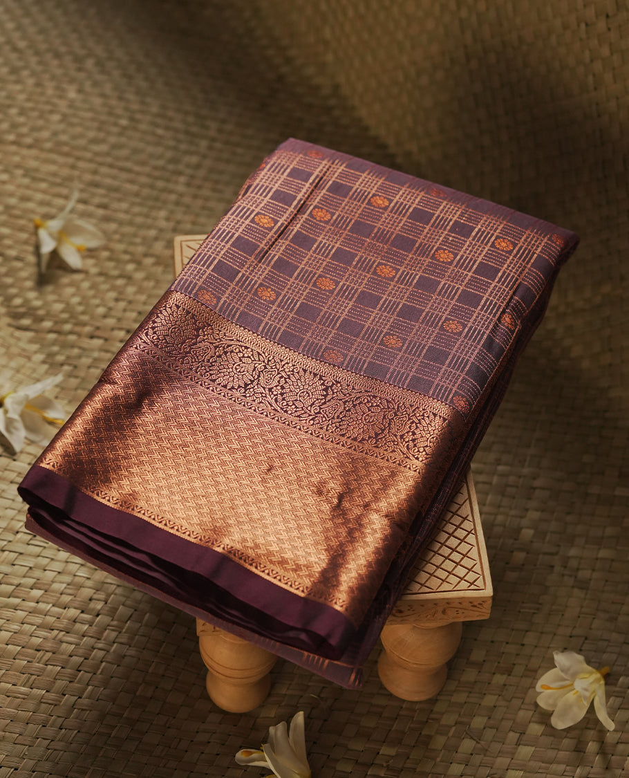 Dusty purple colour Semi Silk Saree with copper zari checkered on the body, paired with a contrast Dark maroon colour pallu with copper zari traditioal border, and a matching blouse piece.