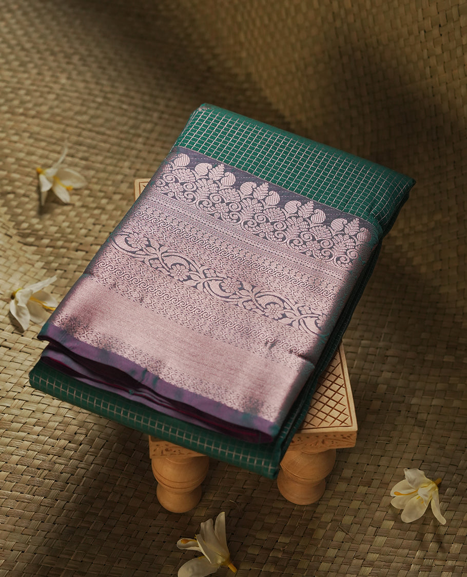 Pine green colour Semi Silk Saree with rose gold zari checkered on the body, paired with a contrast Teal green colour pallu with rose gold zari traditioal border, and a matching blouse piece.