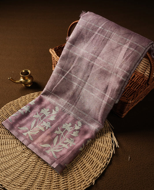 Light Rose copper colour semi tussar saree adorned with Cream strip printed pattern across the body and Floral pattern contrast rose copper colour on border, paired with a matching blouse.