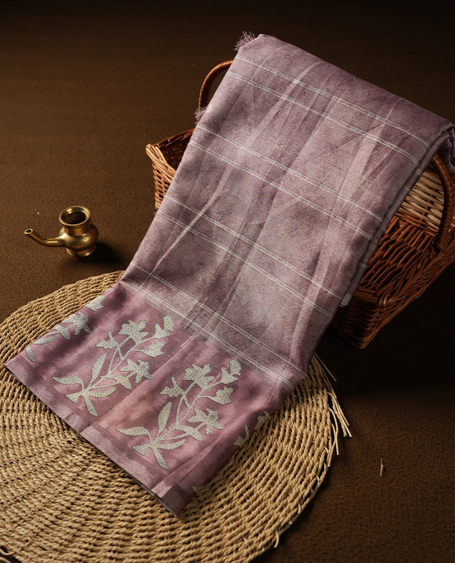 Light Rose copper colour semi tussar saree adorned with Cream strip printed pattern across the body and Floral pattern contrast rose copper colour on border, paired with a matching blouse.