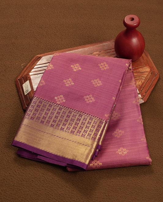 Twilight lavender colour semi soft silk saree featuring a golden textured patterned body, complemented by contrast purple with golden motifes on pallu & border and a matching blouse piece.