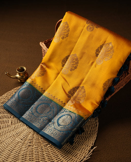 Mustard Colour Pure Banaras soft Silk Saree having gold floral motifs on Body with contrast Teal colour gold Floral kodi pattern on Border and matching Blouse