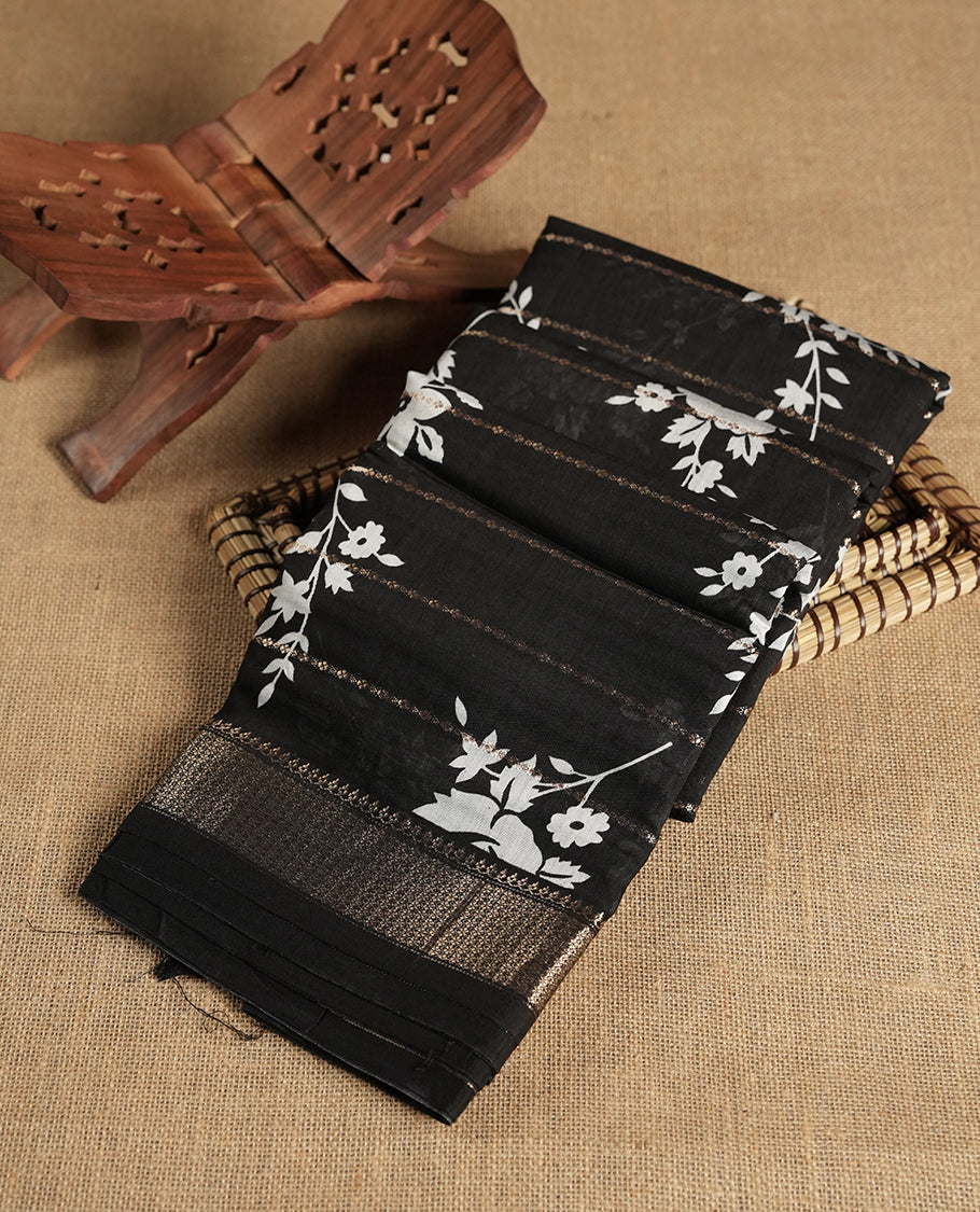 Black colour chanderi silk saree with gold zari strip pattern & white Floral print pattern On body, compilmented by self colour border with antique zari pattern and a matching blouse.