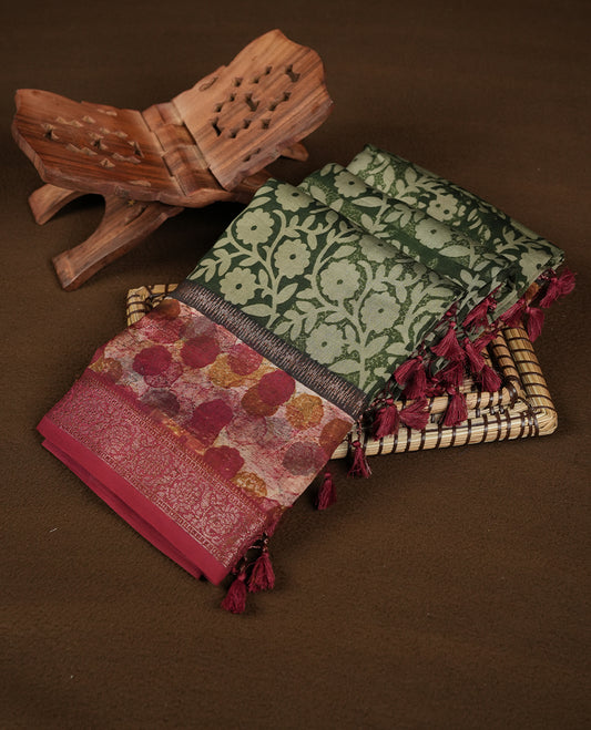 Dark green colour chanderi silk saree featuring floral kodi print pattern across body, with contrast red colour border with zari pattern and paired with matching blouse.