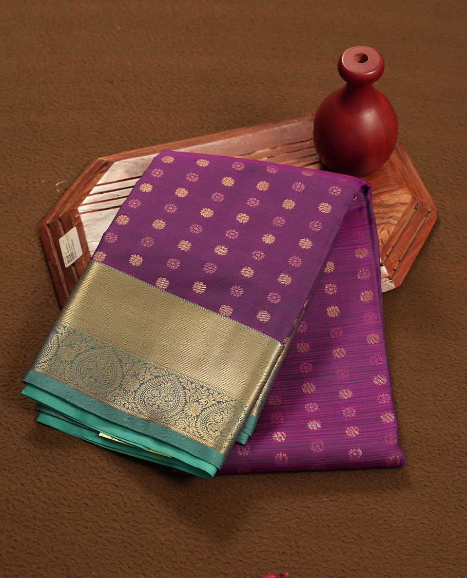 Very Dark purple colour semi soft silk saree featuring a gold coloured textured patterned body, complemented by contrast green with golden zari motifes on pallu & border and a matching blouse piece.