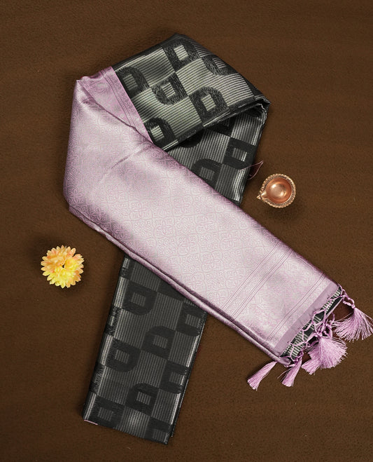 Black colour semi silk saree adorned with silver zari designs on the body, complemented by a contrasting light pink border and pallu, and paired with a matching blouse piece