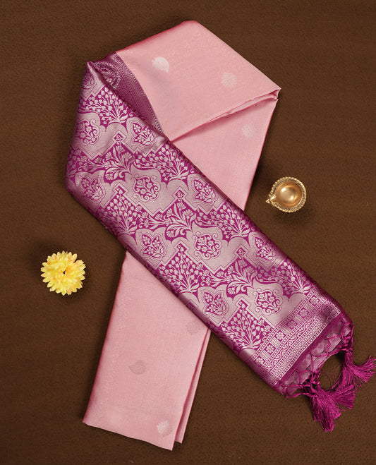 Light pink colour semi silk saree adorned with silver leaf motifs on the body, complemented by a purple pallu intricately woven with rich floral patterns border and pallu, and paired with a matching blouse