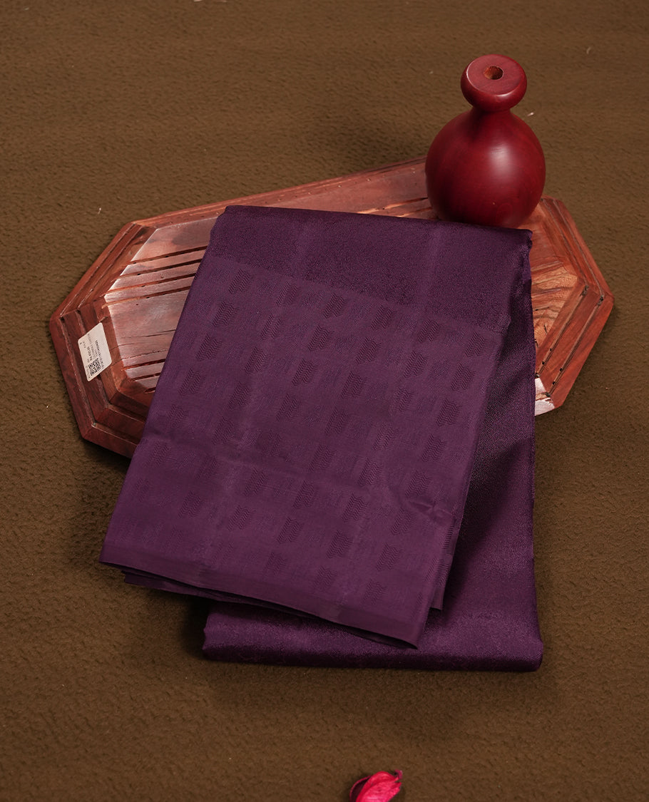 Dark purple  colour semi soft silk saree featuring a self coloured textured patterned body, complemented by self coloured motifes on pallu & border and a matching blouse piece.