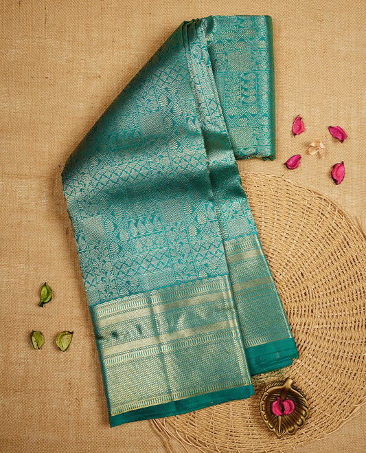 Peacock blue colour Kanchipuram Samudrika Silk Saree featuring Floral kodi in square pattern weaving with gold zari jacquard and a traditional zari border, paired with a matching designer jacquard blouse piece