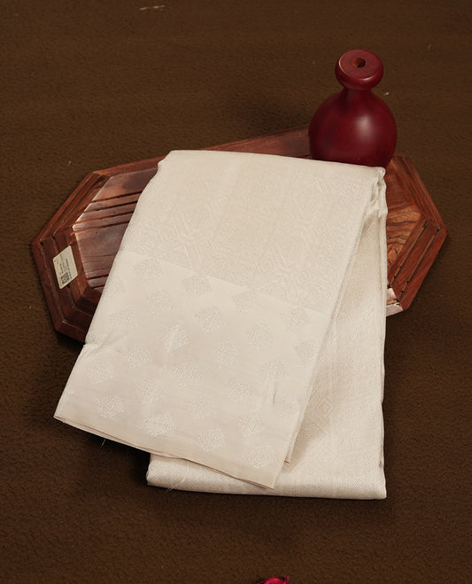 Off white colour semi soft silk saree featuring a self coloured textured patterned body, complemented by self coloured Square motifs on pallu & border and a matching blouse piece.