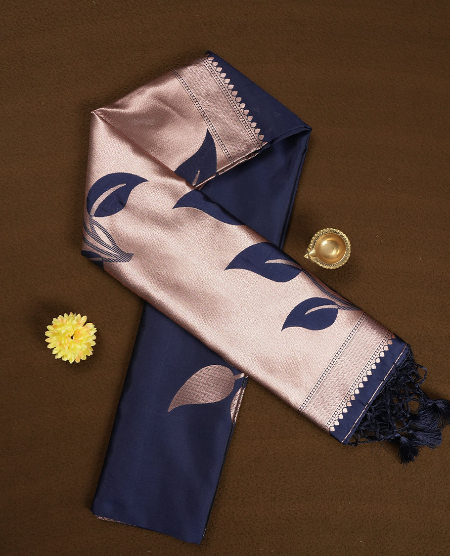 Dark blue colour semi silk saree adorned with elegant floral motifs on the body, complemented by a shimmering golden zari-woven pallu and border, and paired with a matching blouse